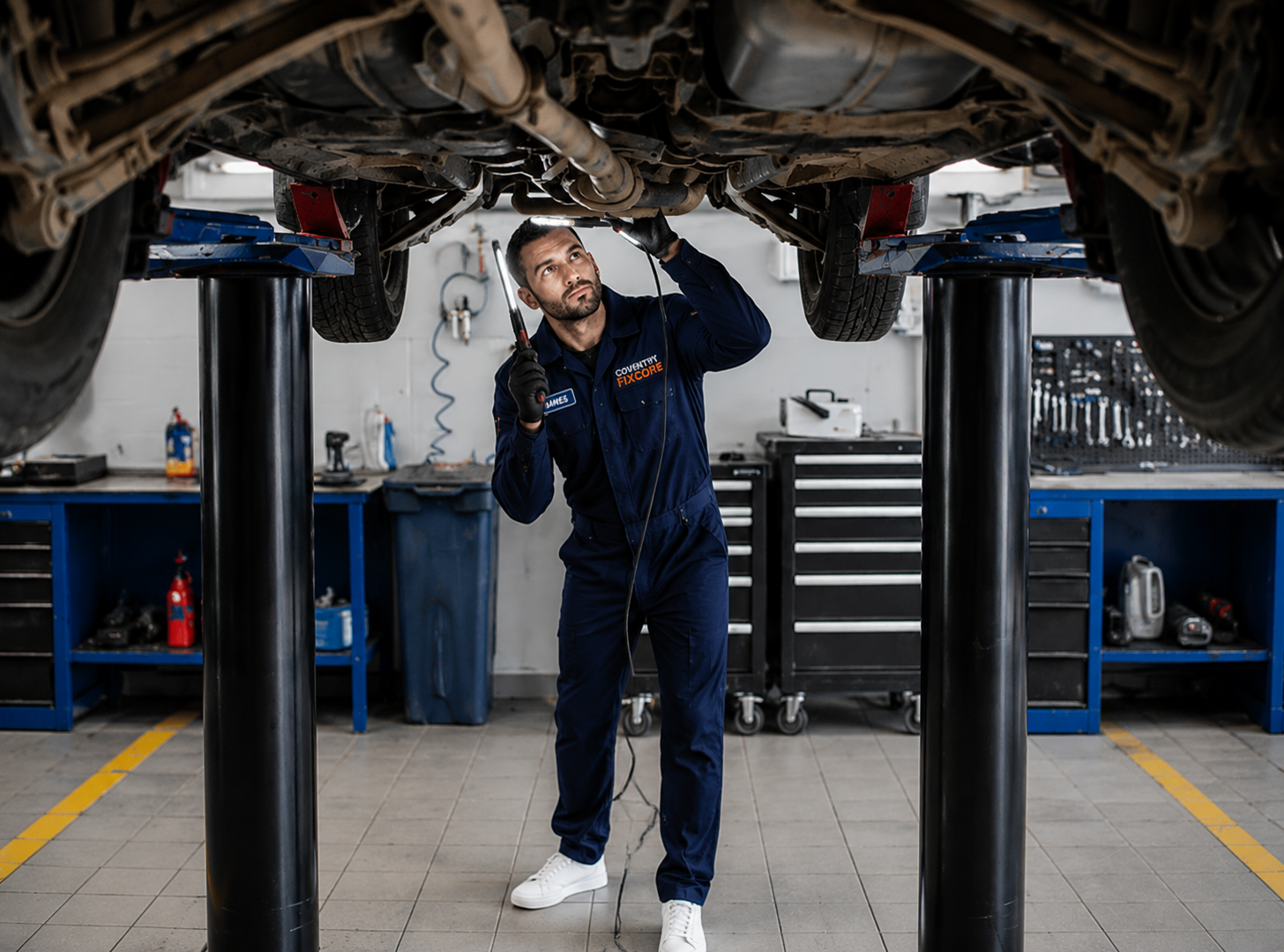 Coventry Fixcore mobile mechanic using battery charger and diagnostic equipment on car battery during vehicle repair service