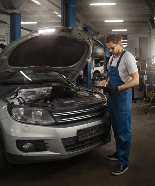 male-mechanic-working-shop-car